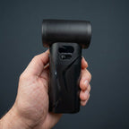 Close-up studio view of the AirBlaster Pro being held in hand, highlighting the digital display screen and power button on the back handle.