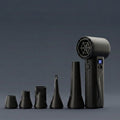 Studio product photograph of the AirBlaster Pro electric duster, a black, pistol-grip device with a digital display, lined up with four distinct black nozzle attachments against a dark grey background.