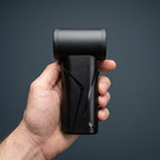 Studio photo showing the AirBlaster Pro electric duster held comfortably in a person's hand, displaying its compact size and side profile.